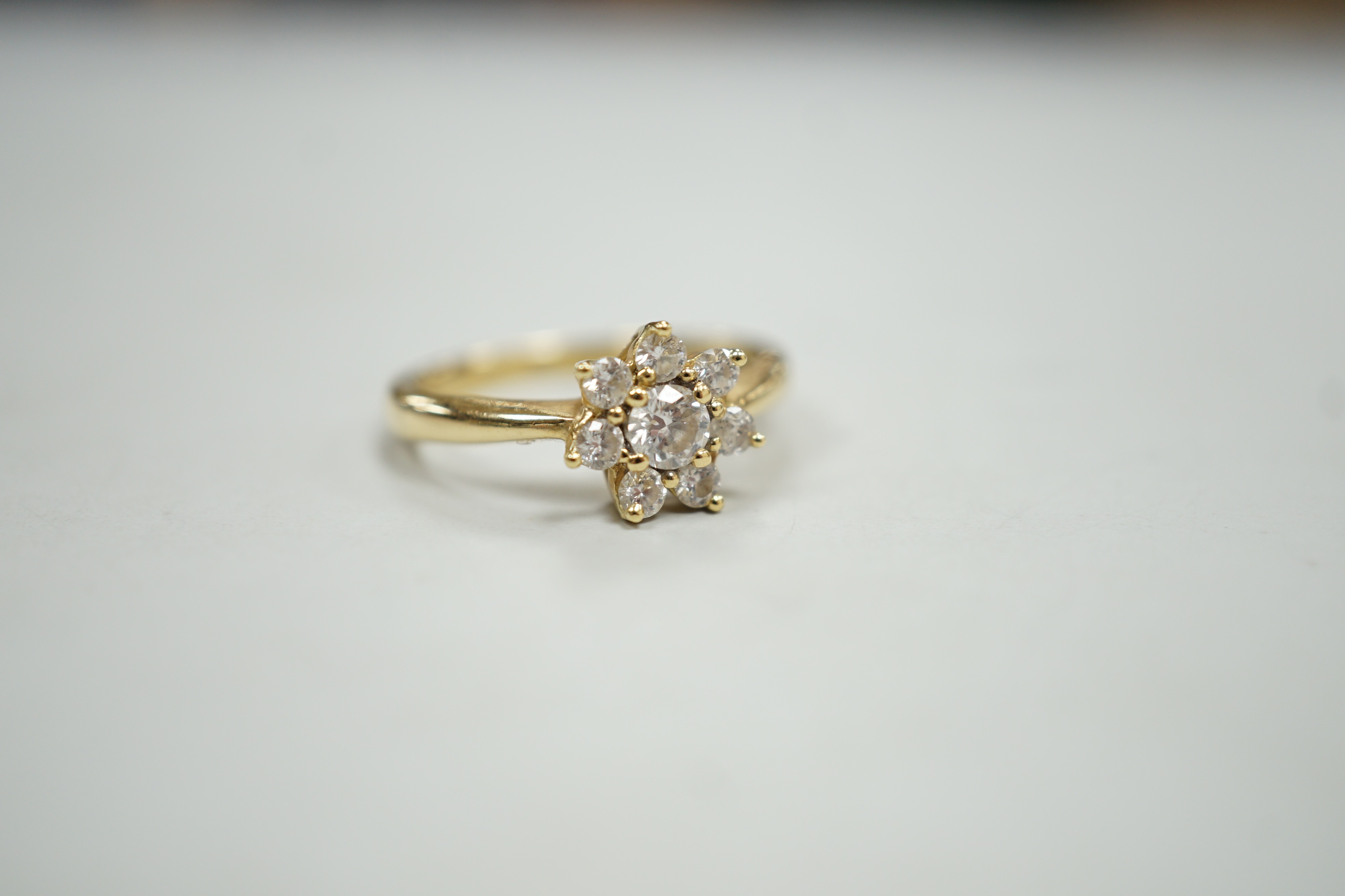 A modern yellow metal and diamond set flower head cluster ring, size L, gross weight 2.9 grams.